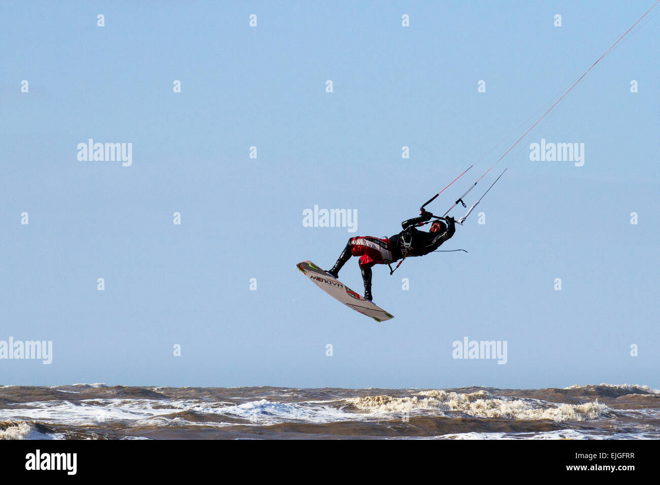 Ainsdale, Southport, Merseyside, UK 26th March, 2015.  UK Weather at beach Kite Surfing zone Ainsdale-on-Sea with  High Tides & High Winds.  A kiteboarder harnessing the power of the strong wind with a large controllable power kite propelled across the incoming tide, on a kiteboard.  Sefton Council are now issuing permits for use of Kitesurfing at Ainsdale Beach. Credit:  Mar Photographics/Alamy Live News Stock Photo