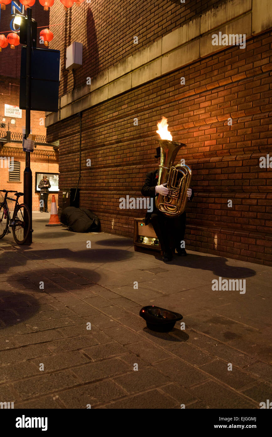 London street artist performing with flaming musical instrument. Stock Photo