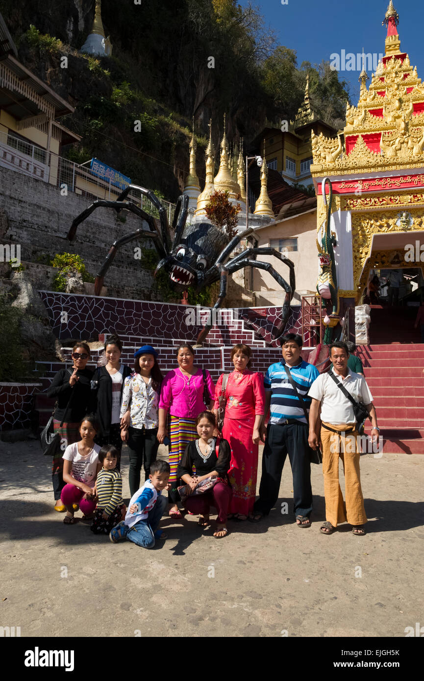 Smile. A group pose beneath the Giant Spider at the Temple Caves of Shwe Oomin Stock Photo
