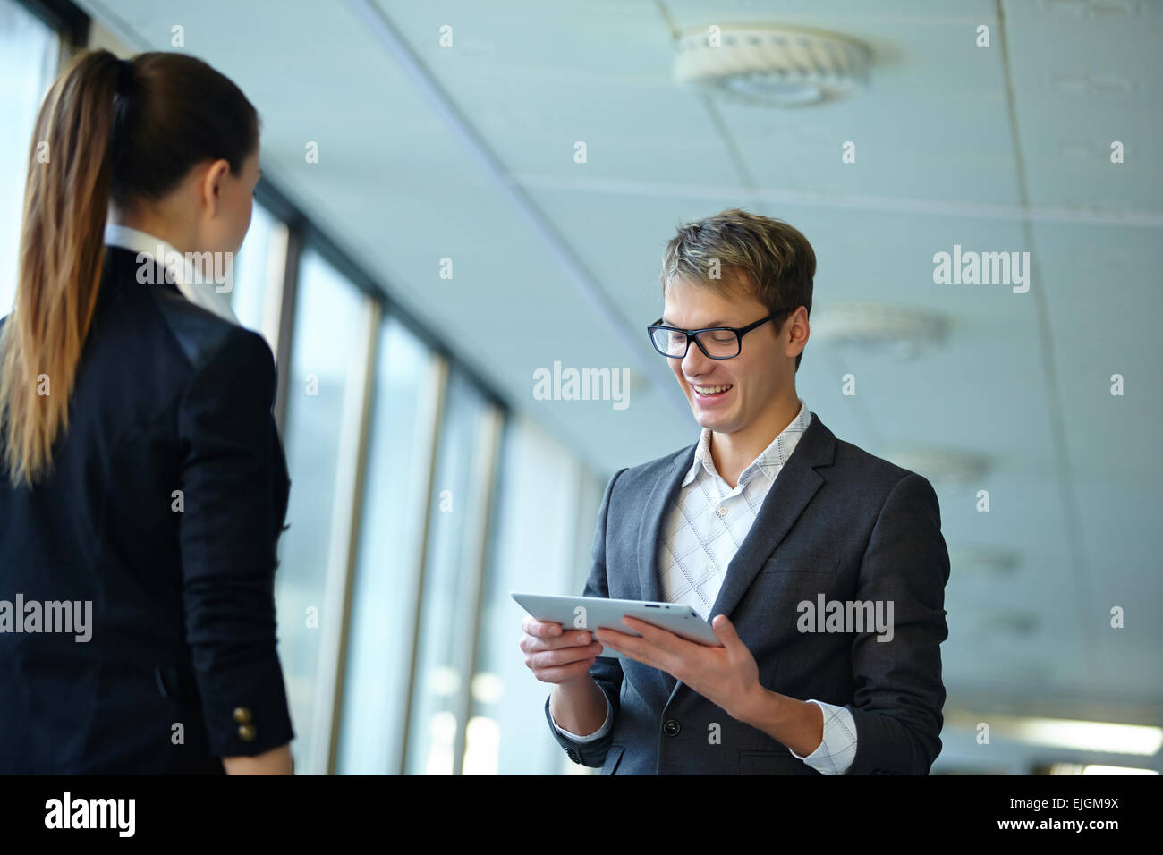 Young business woman and businessman in the hallway Stock Photo - Alamy