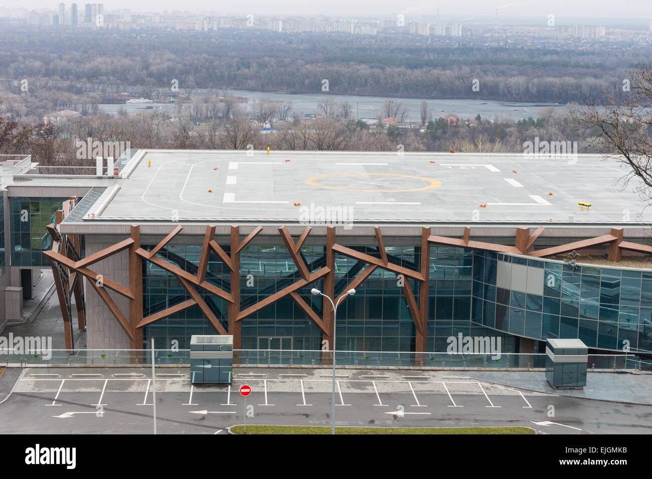 Helicopter Landing Pad on Roof of Modern Building with Urban City in