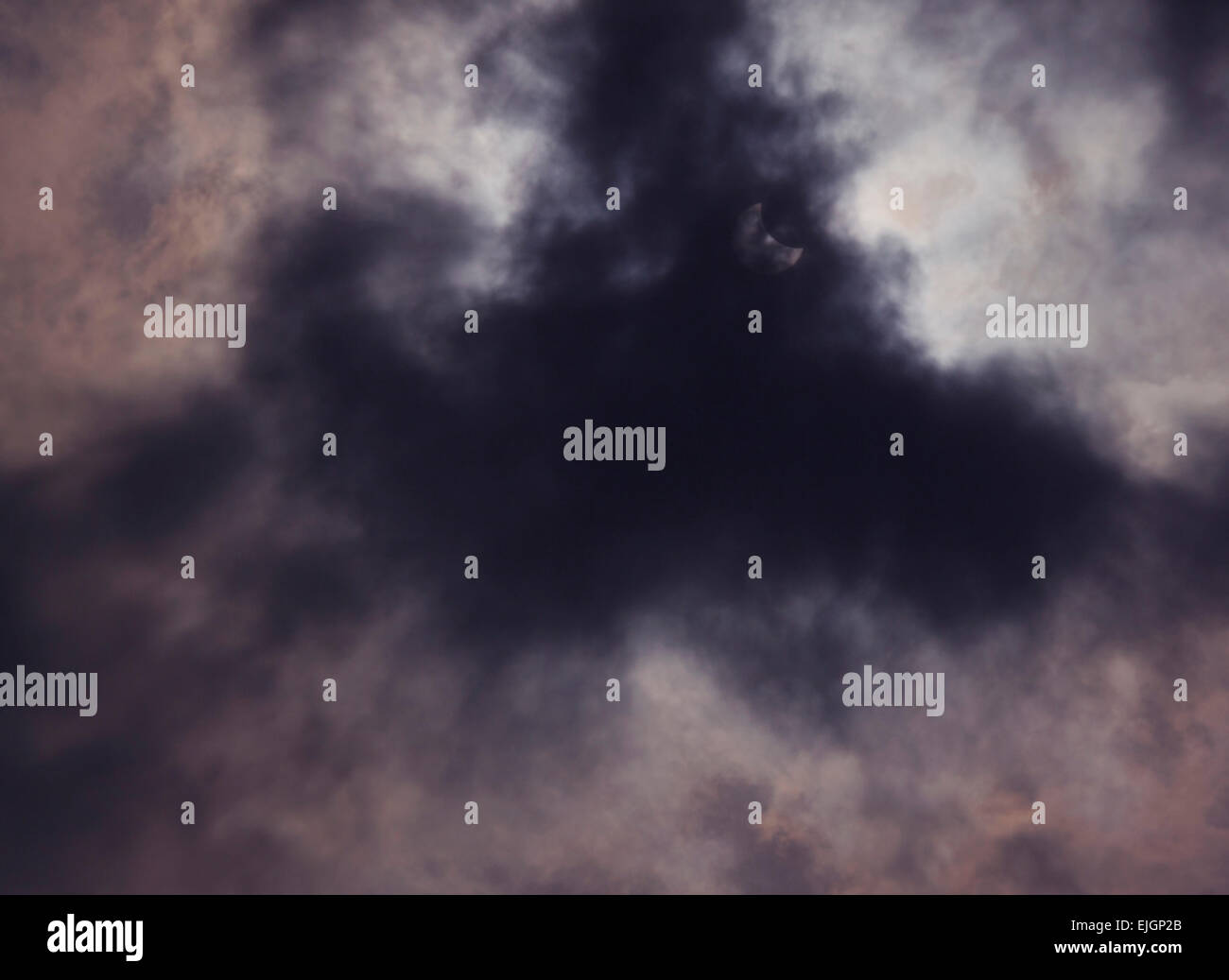 view on partial solar eclipse behind clouds Stock Photo