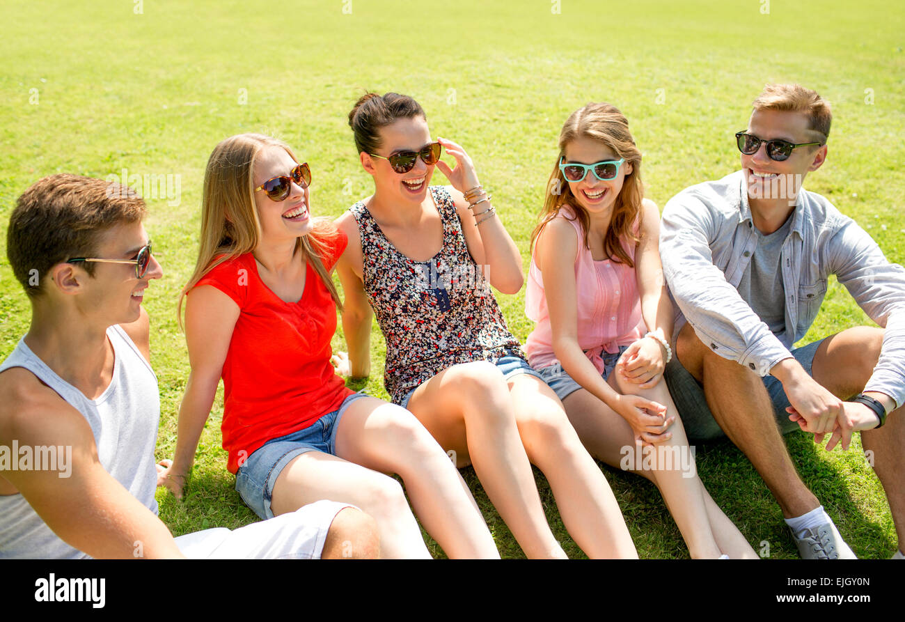 group of smiling friends outdoors sitting in park Stock Photo - Alamy