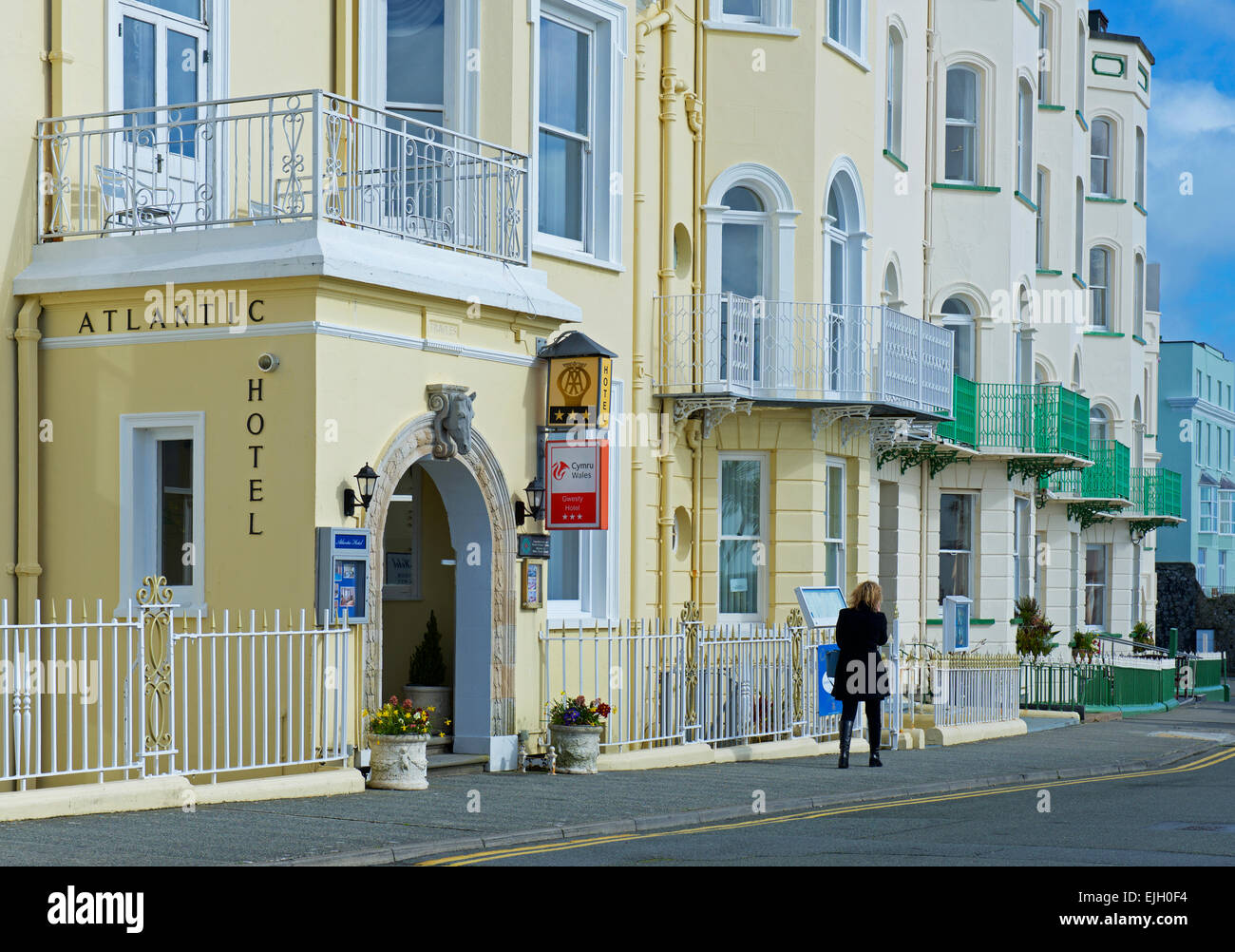 Woman walking past the Atlantic Hotel in Tenby, Pembrokeshire, Wales UK Stock Photo