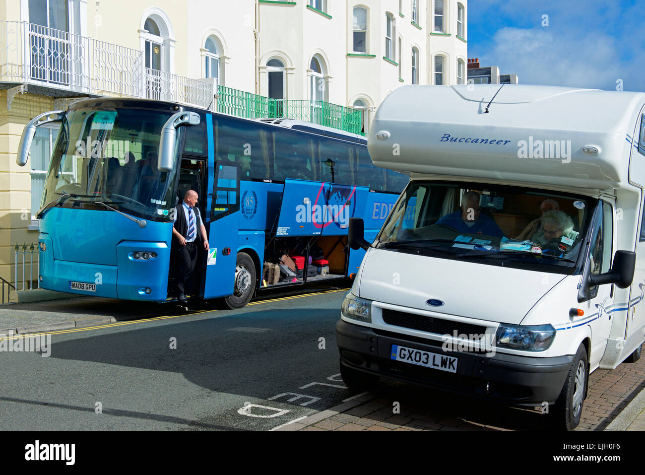 Tourist coach and motorhome parked on street, in front of hotels, in Tenby, Pembrokeshire, Wales UK Stock Photo