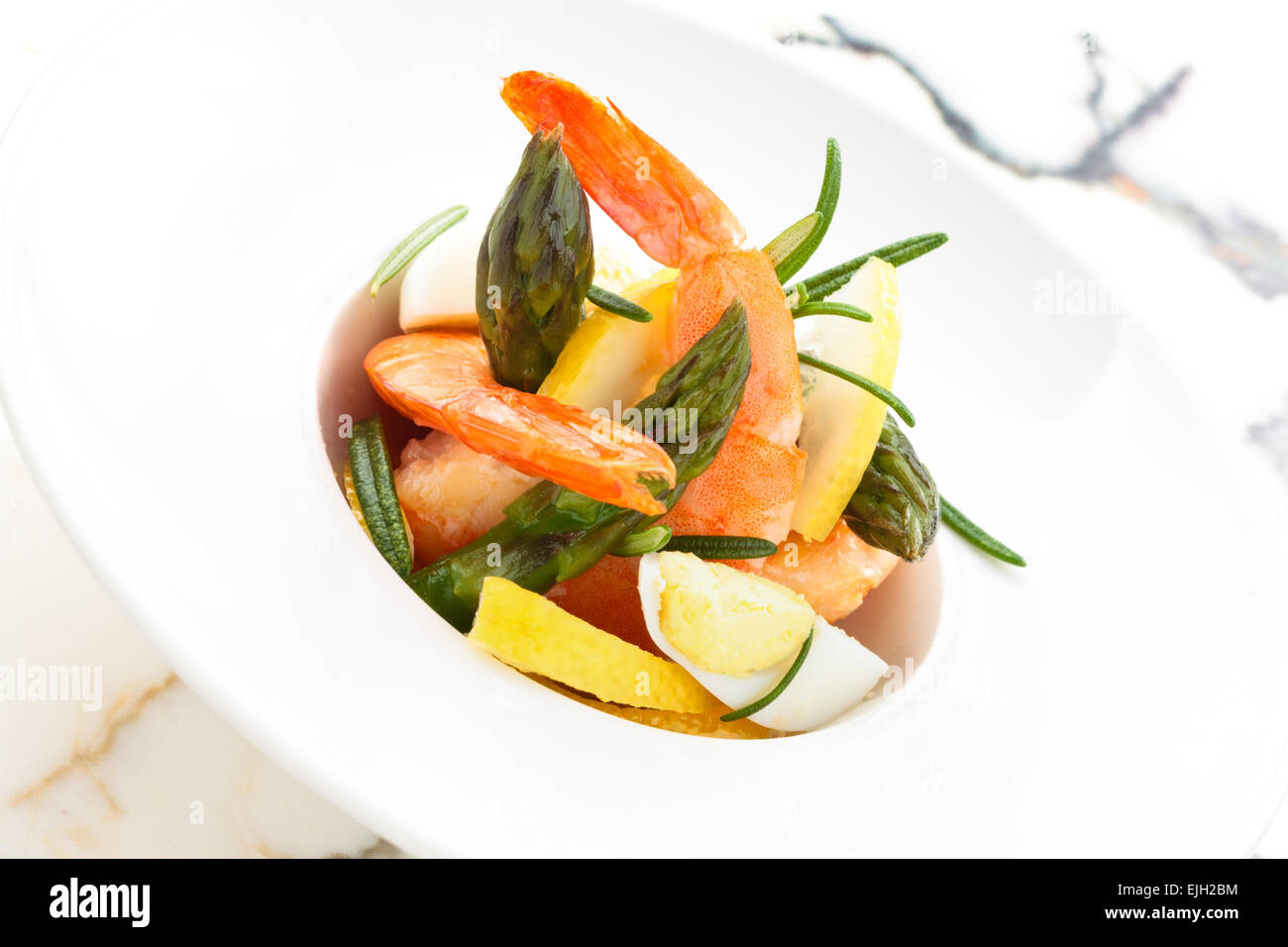 Salad with prawns, quail eggs asparagus and lemon. Stock Photo