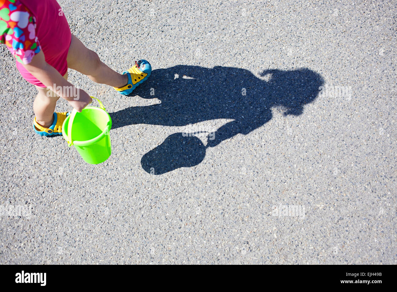 Shadow of a young girl walking with her beach bucket Stock Photo Alamy