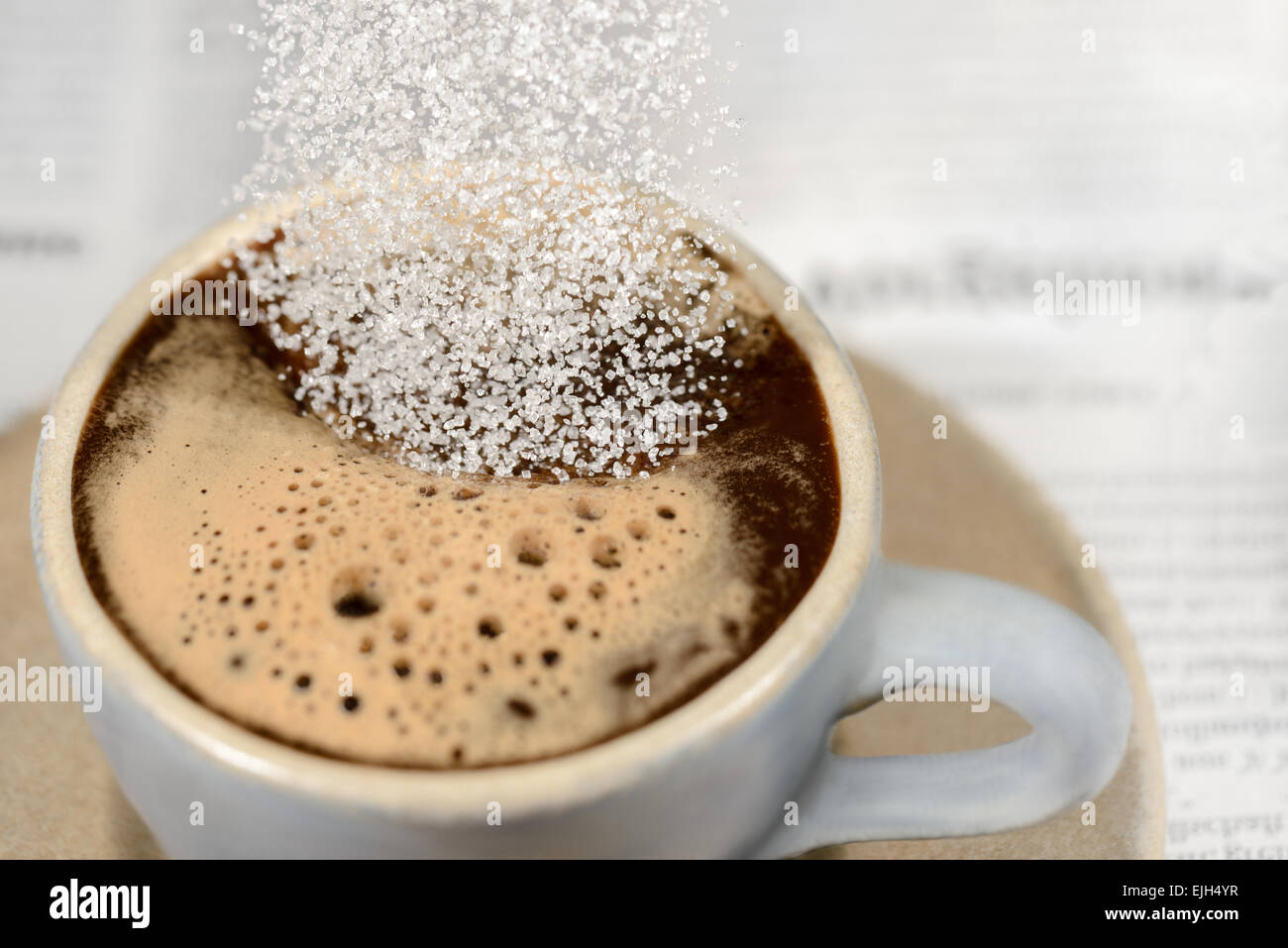 Sweetening coffee expresso by sugar pouring Stock Photo