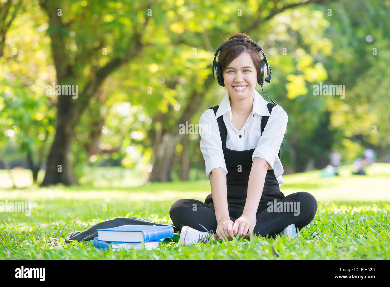 Young beautiful Asian woman listening music in headphones Stock Photo ...