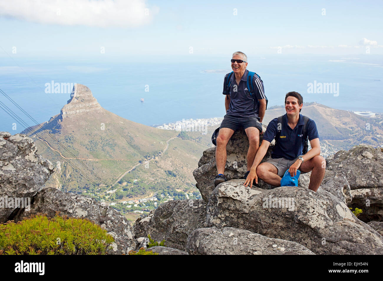 Aerial view - a father and son posing on Table Mountain with Lions Head in the background Stock Photo