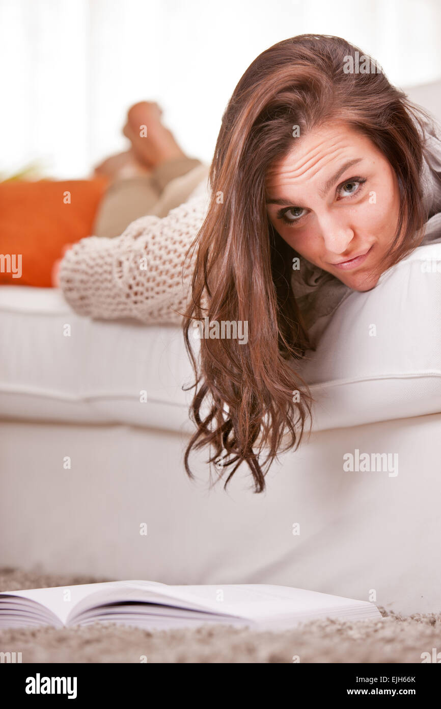 girl reading a book on her living room on a sofa Stock Photo - Alamy