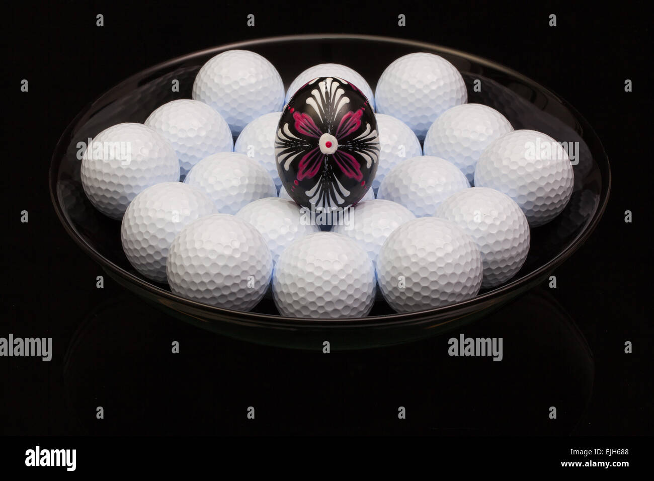 Golf balls and egg in a black bowl Stock Photo Alamy