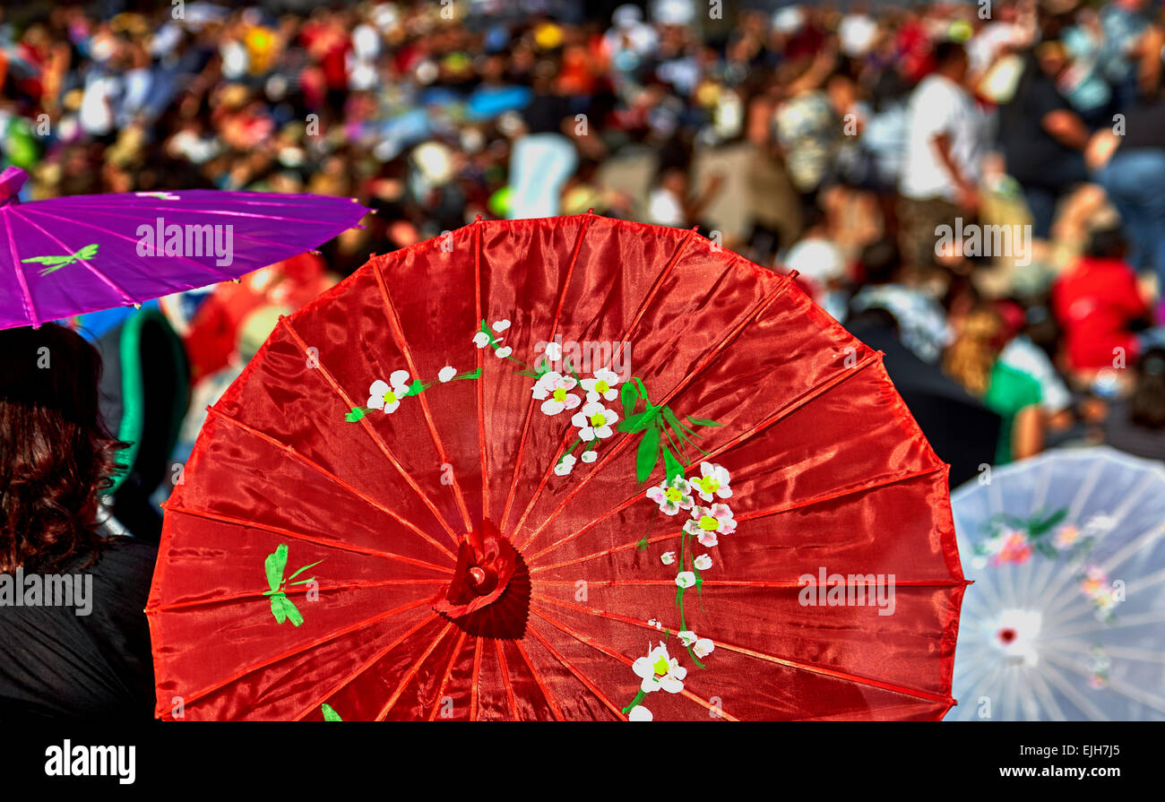 Crowd of people watching the Aloha Festival Show under sun Umbrellas Stock Photo