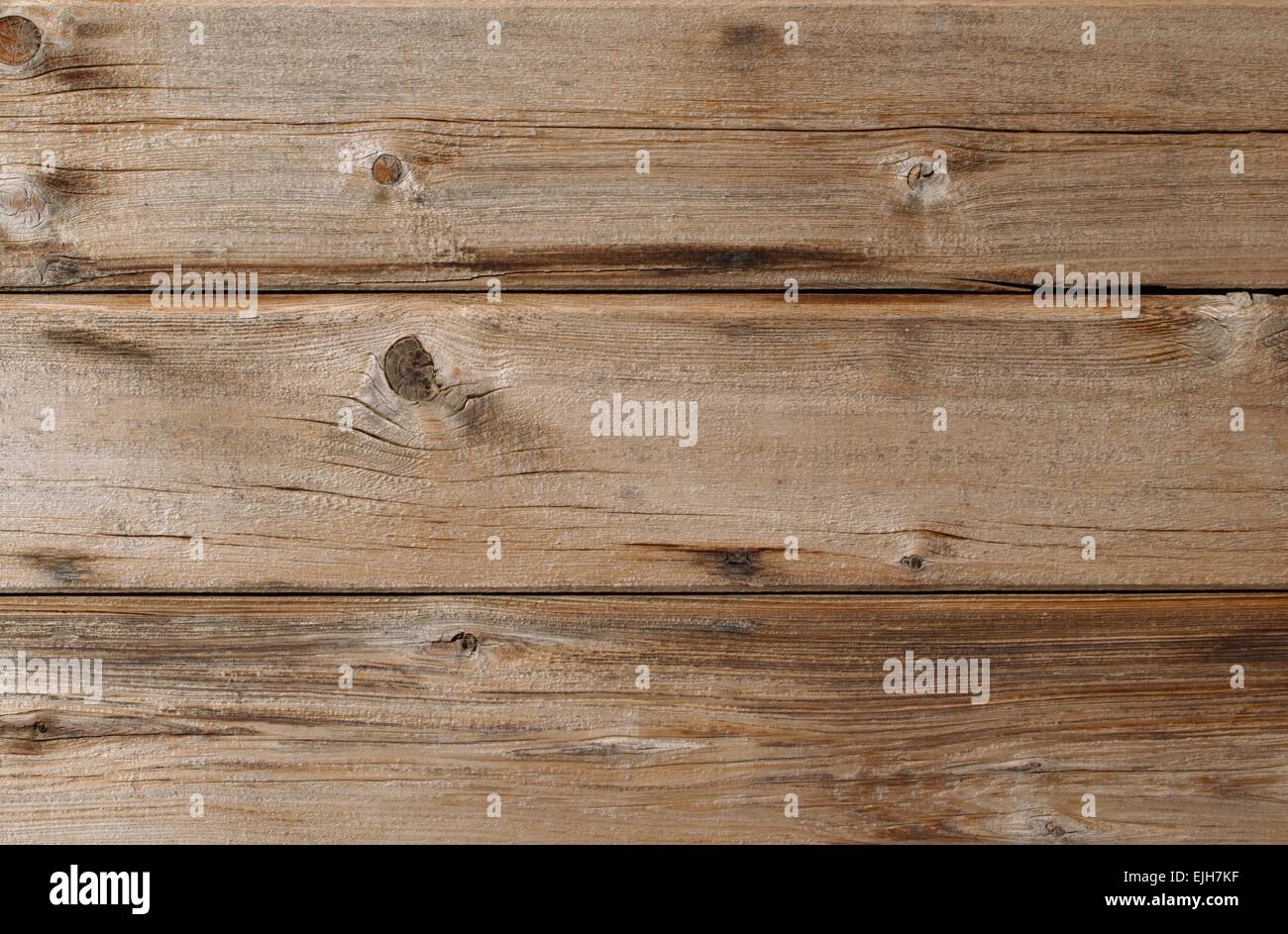 Sun bleached weathered cedar siding wall with knots and wood grain