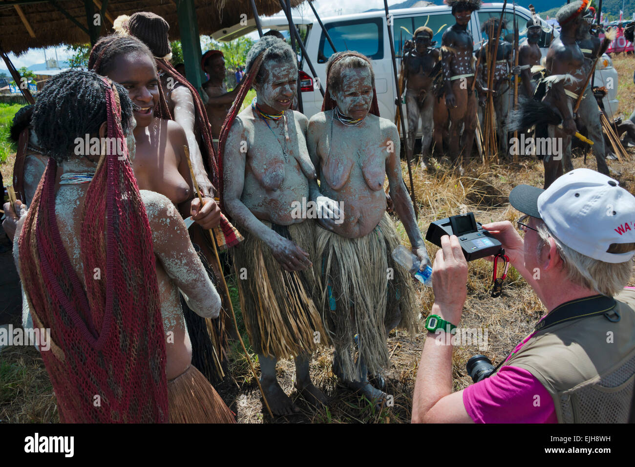 Tourist photographing Dani woman at Baliem Valley Festival, Wamena, Papua, Indonesia Stock Photo