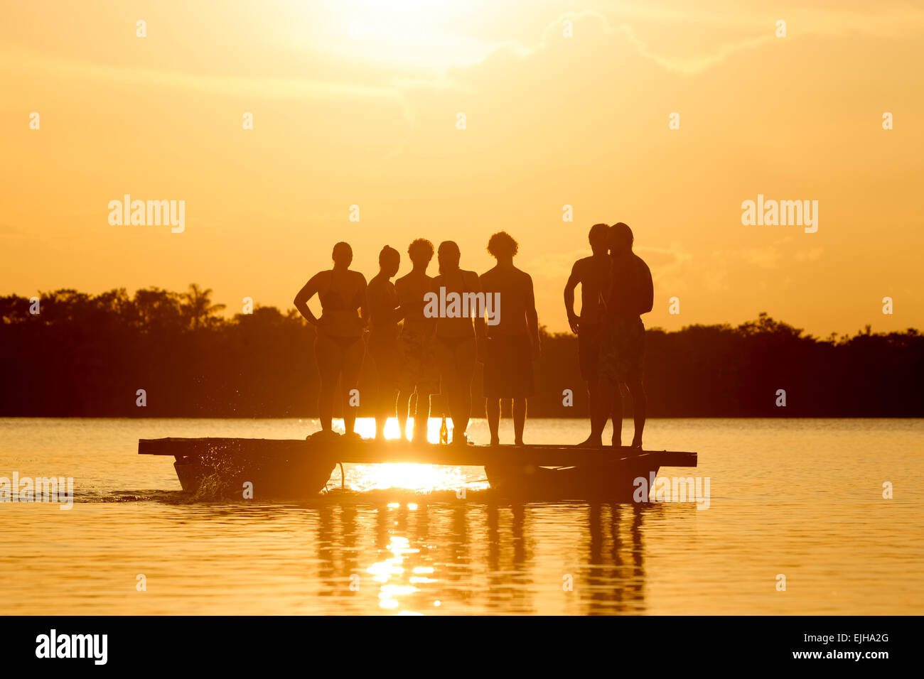 Group Of People On Lake Grande Cuyabeno National Park In Ecuador Against Sunset Stock Photo