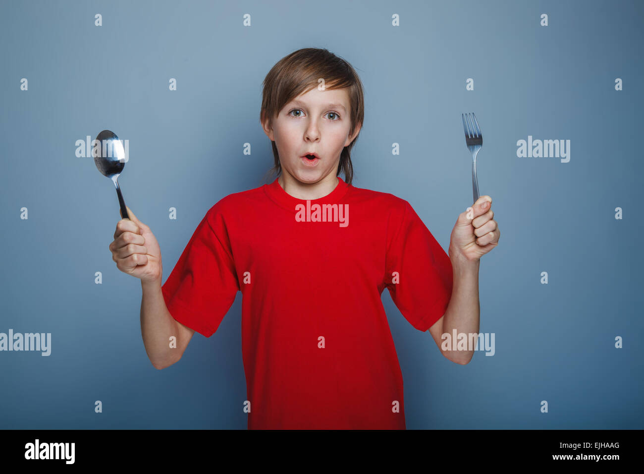 boy teenager European appearance in a red shirt brown hair holdi Stock
