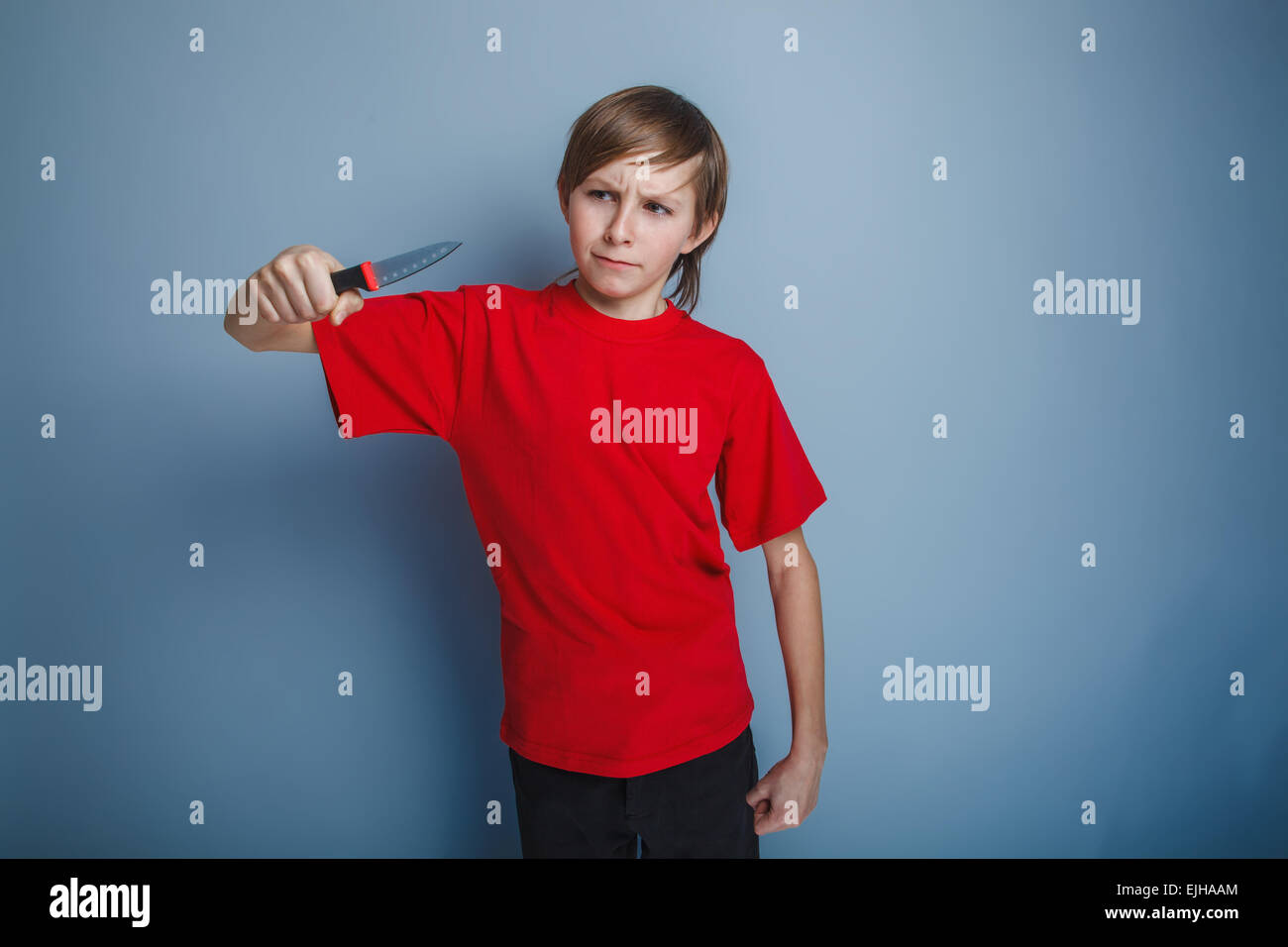 boy teenager European appearance in a red shirt brown hair looks Stock