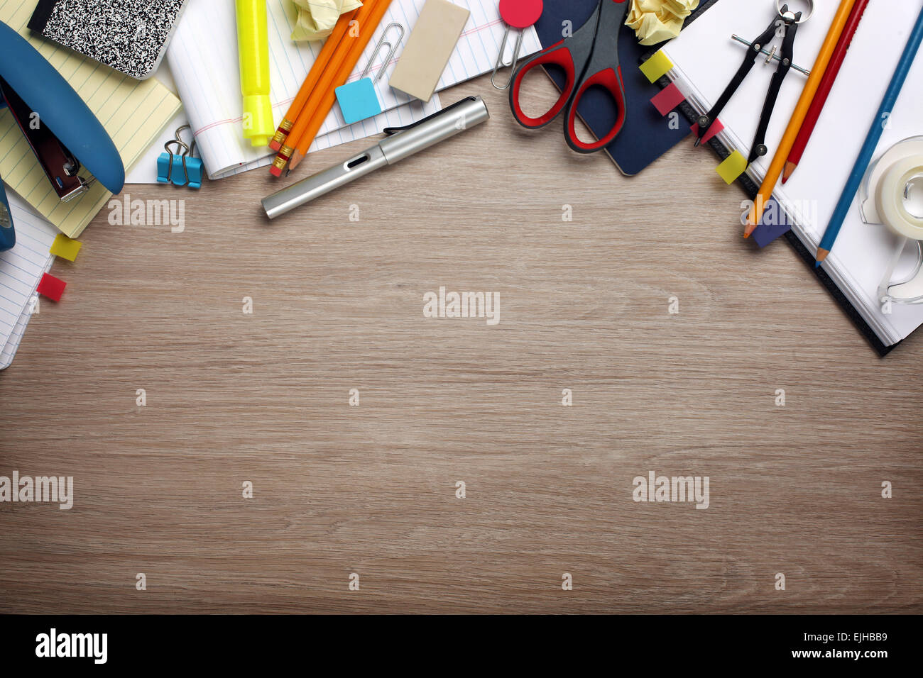 Desk cluttered with office supplies Stock Photo