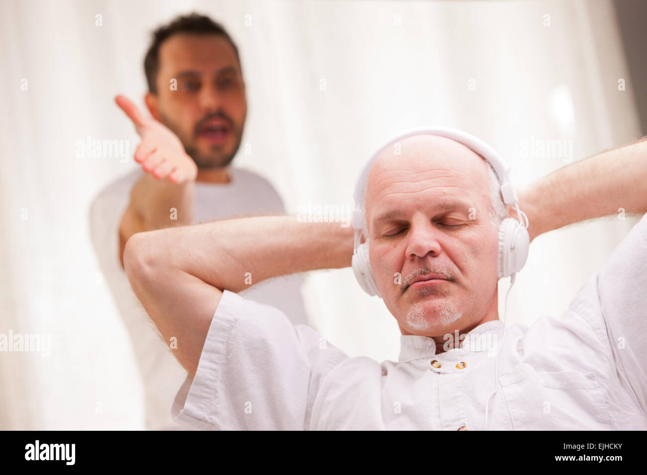 one friend complains to the other one because he listens to music and does nothing else Stock Photo