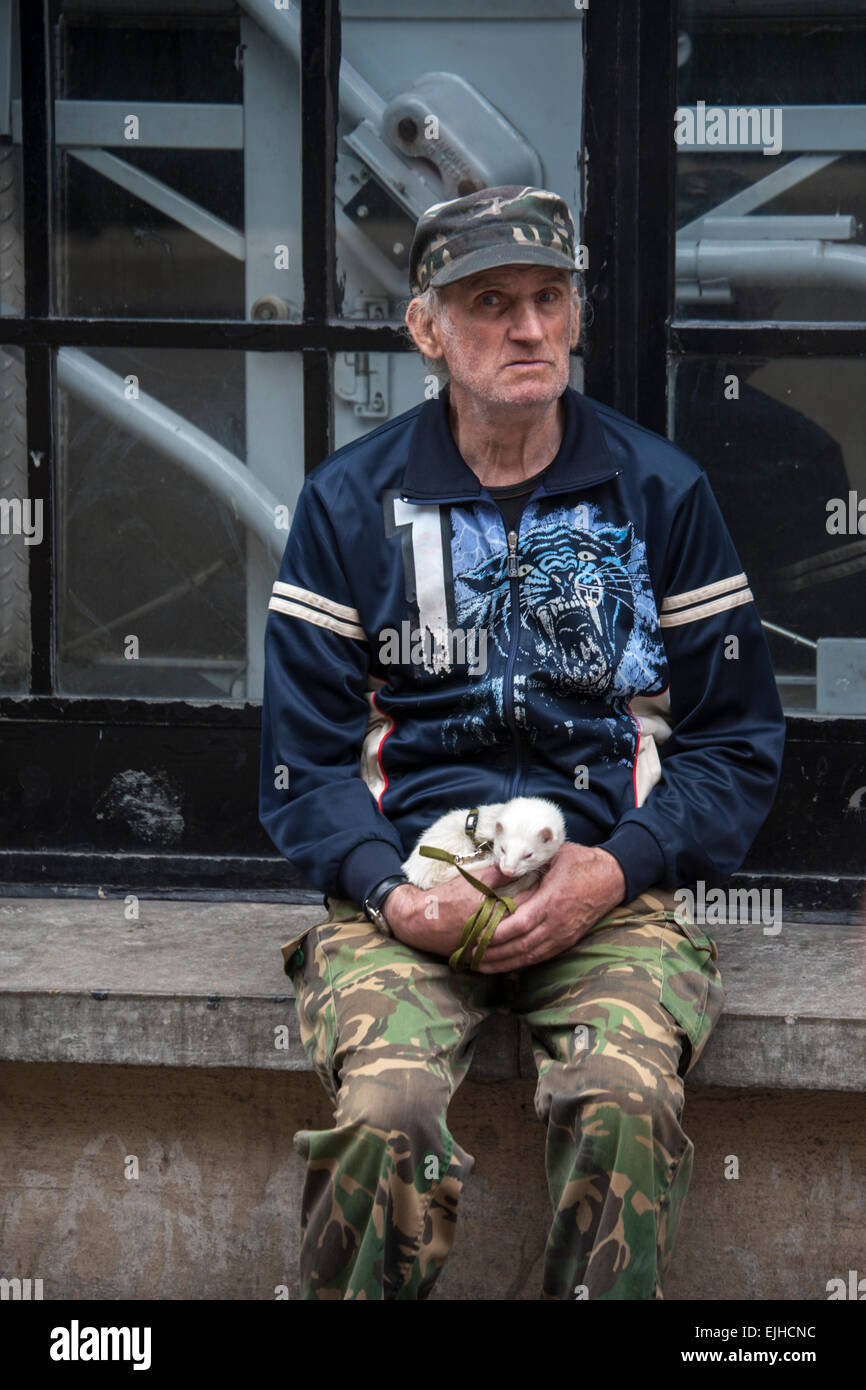 Man holding pet ferret, Covent Garden, London, England Stock Photo