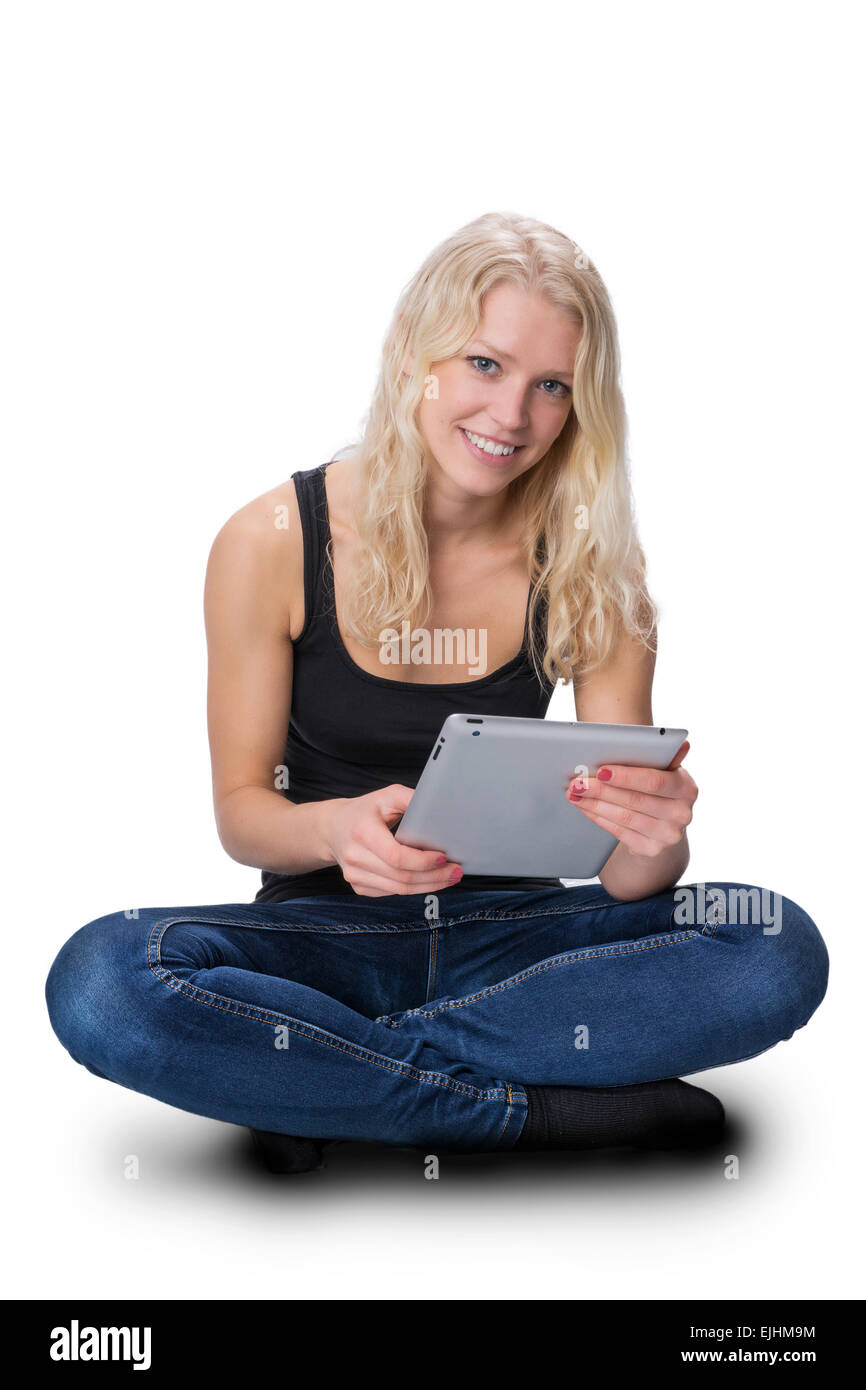 A young pretty girl with blond hair, sitting with a tablet. Stock Photo