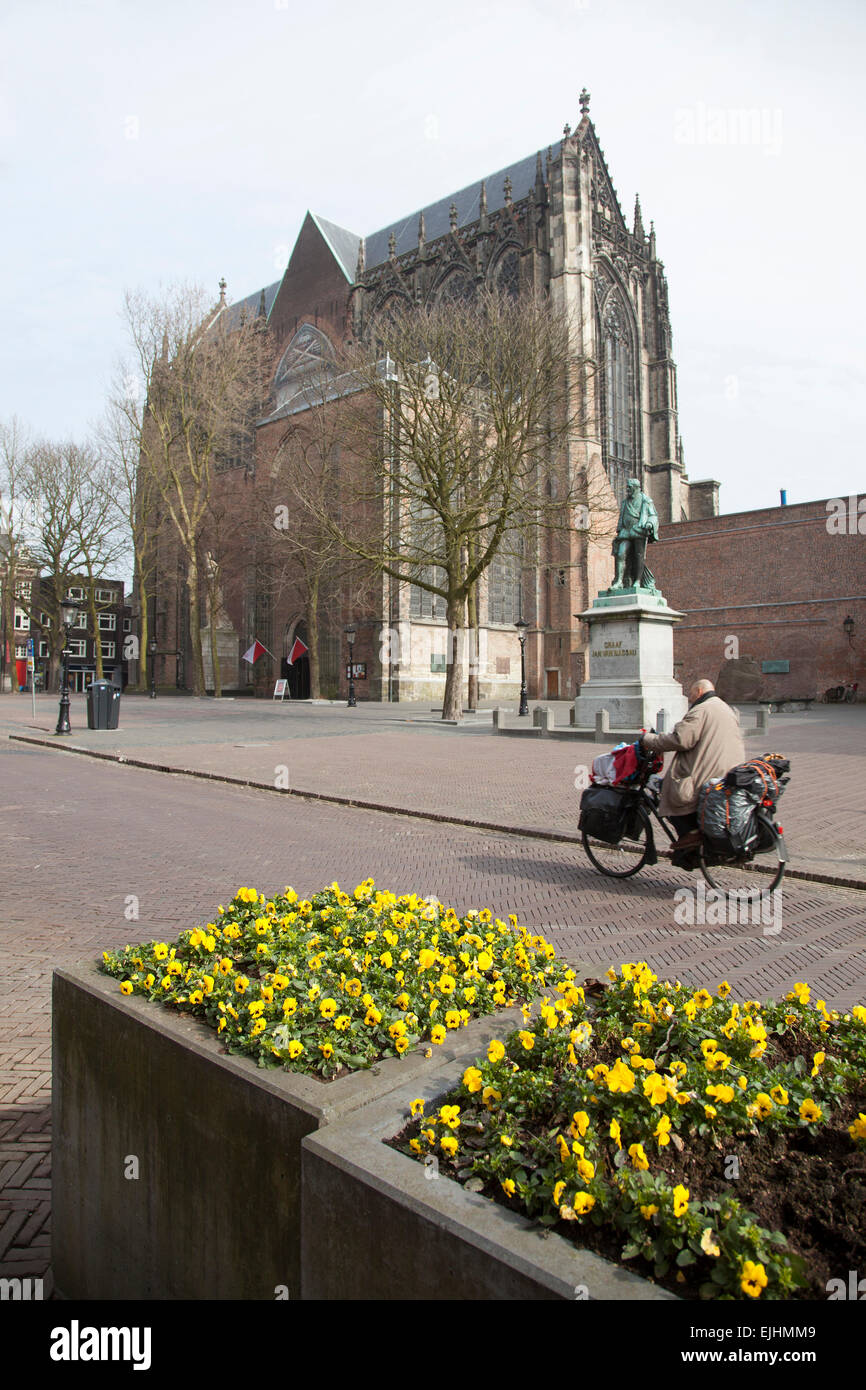 yellow flowers and man on bicycle near dom church in dutch town of utrecht Stock Photo