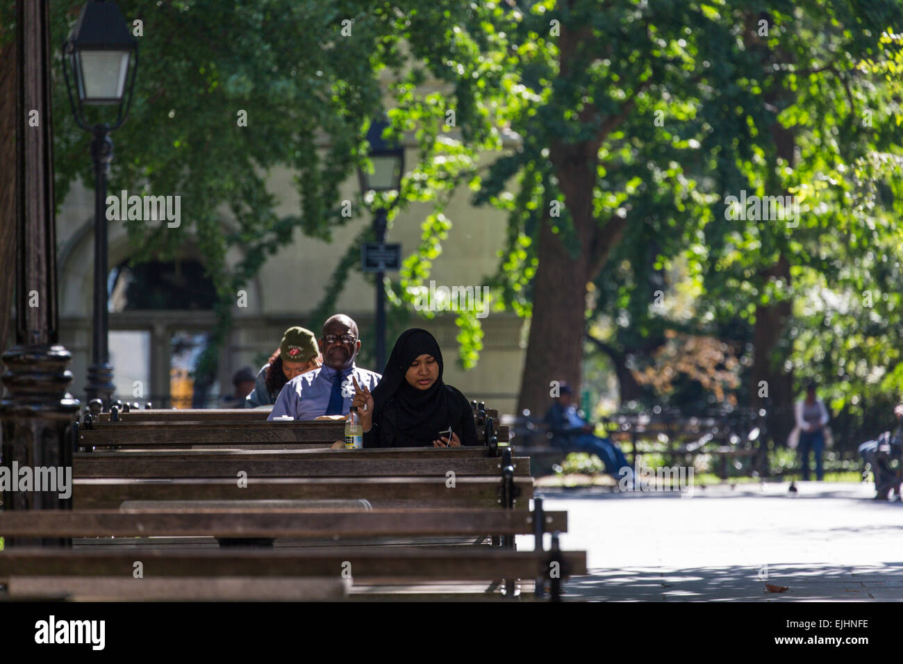 People Sitting On Benches In Park In Manhattan New York City Usa