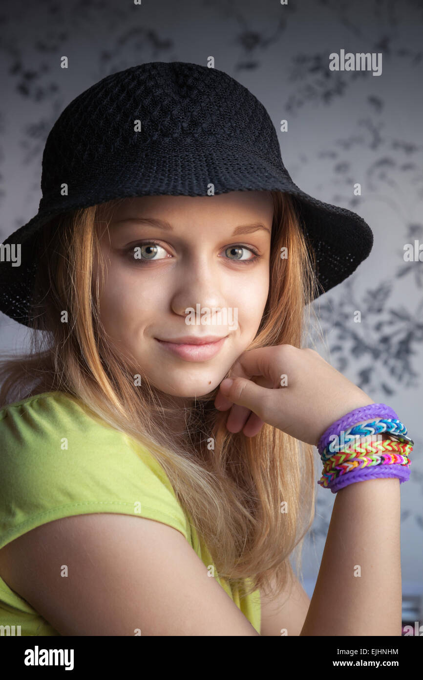 Portrait of beautiful blond teenage girl in black hat and rubber loom bracelets Stock Photo