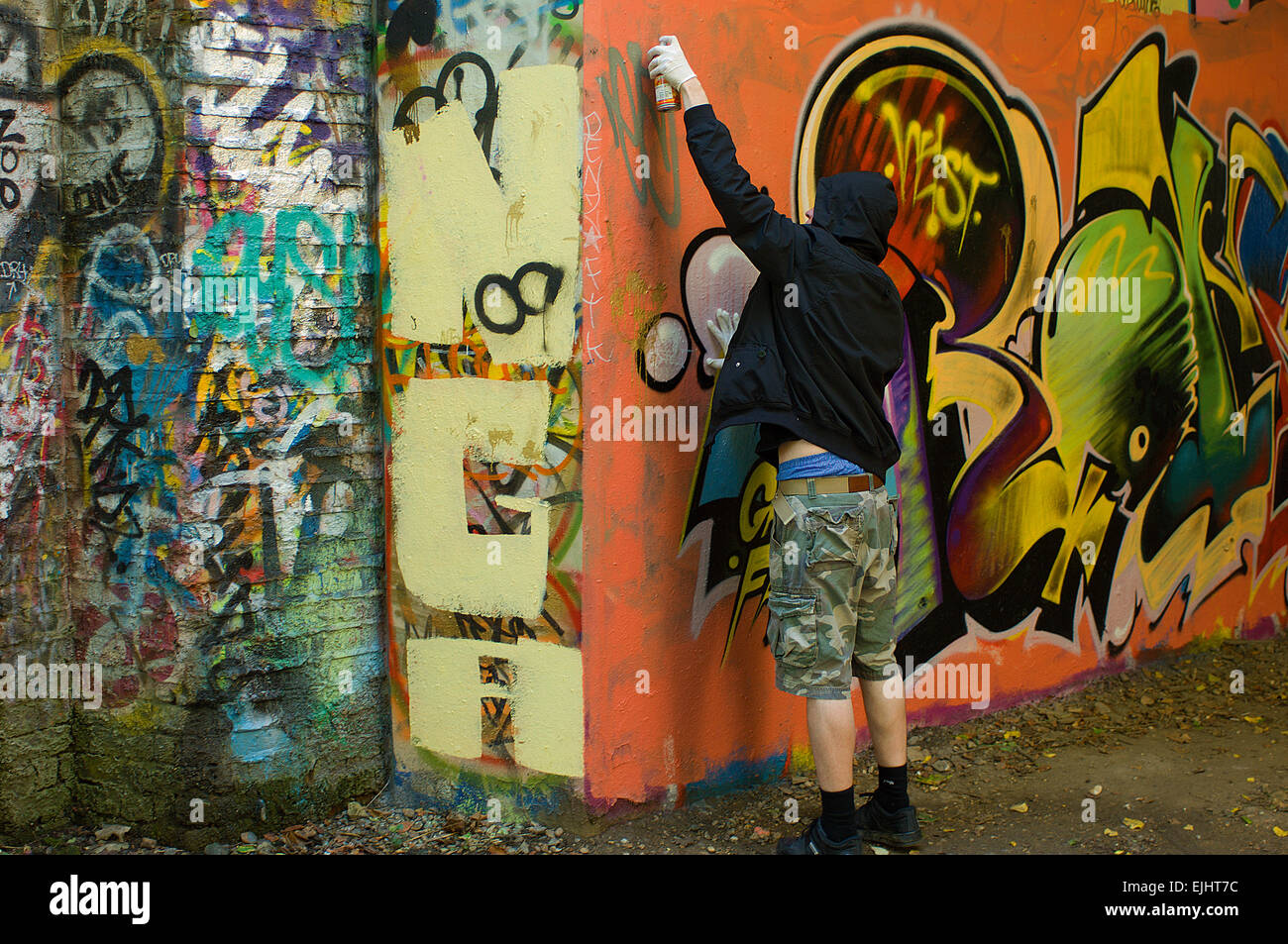 A graffiti artist at work along the Parkland Walk, which runs up a disused railway line from Finsbury Park to Alexandra Palace. Stock Photo