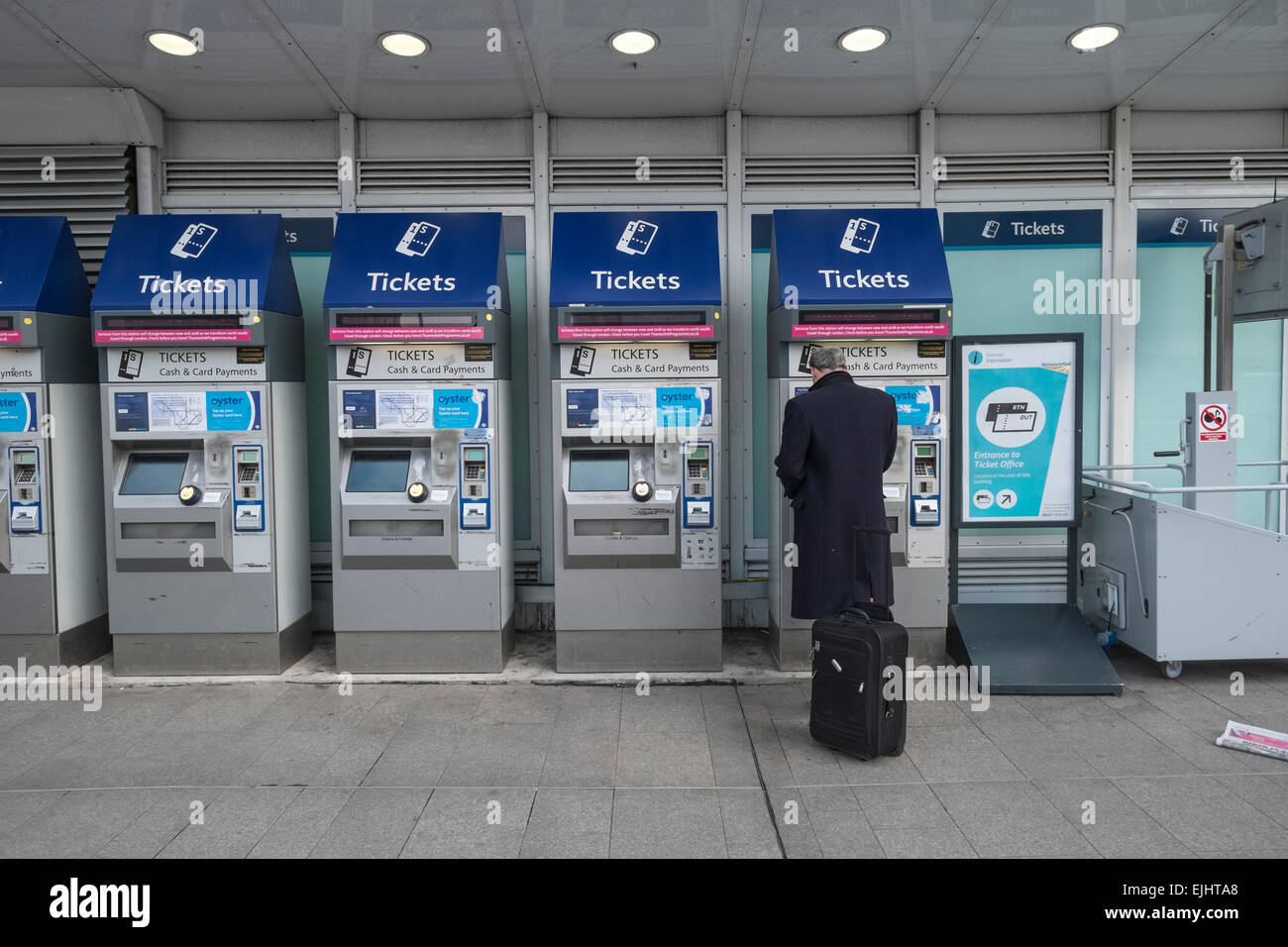 White middle aged male purchasing ticket for trains at London Bridge station. Stock Photo