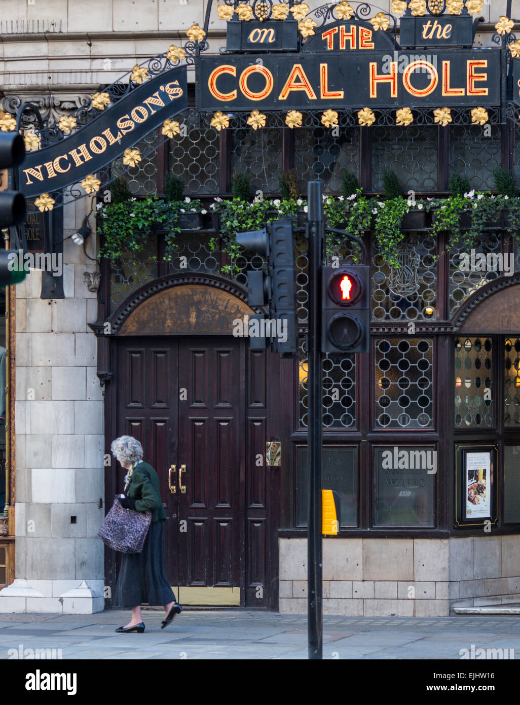 Woman walks past the Coal Hole pub, London, England Stock Photo