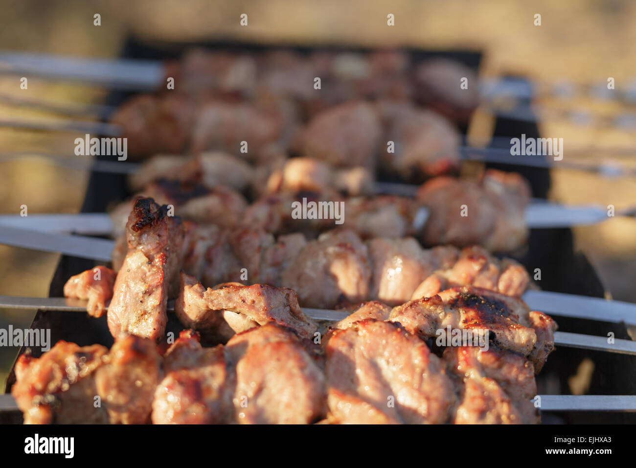 cooking pork shashlik on skewer in mangal outdoor food Stock Photo