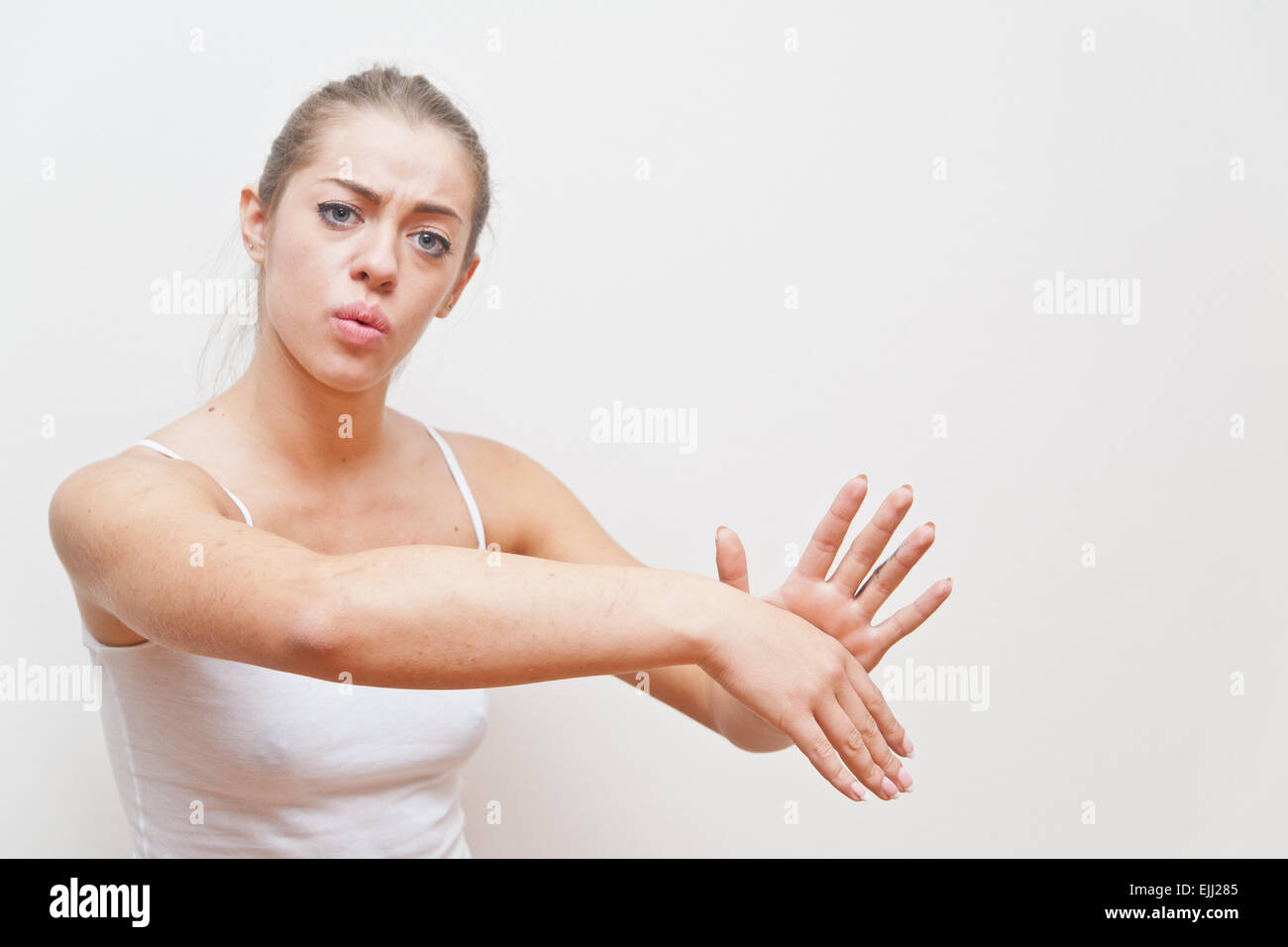 young woman performing hand gesture that stands for AWAY FROM ME or go away from me Stock Photo