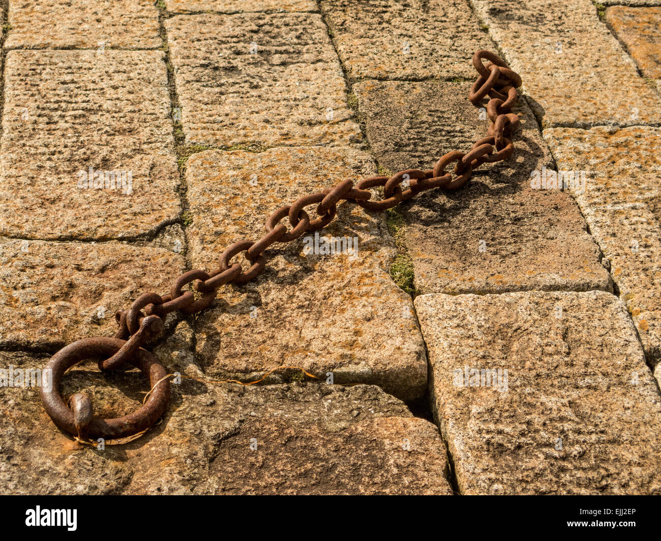 Rusty chain on harbour wall at Binic Brittany Stock Photo