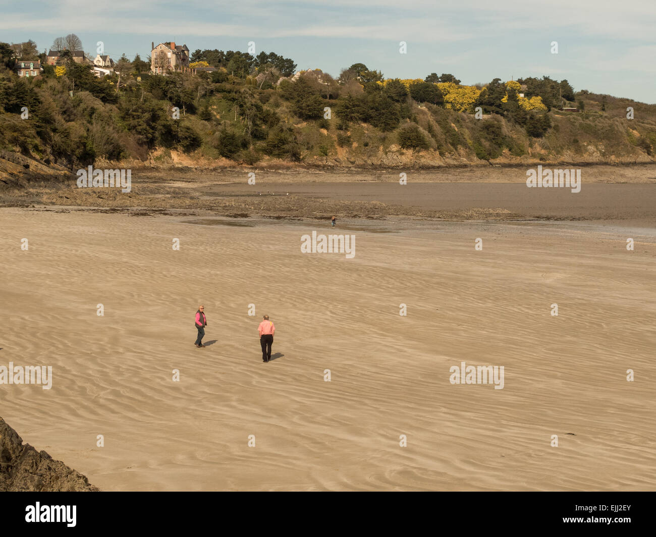 Two people strolling on the beach at Binic Stock Photo