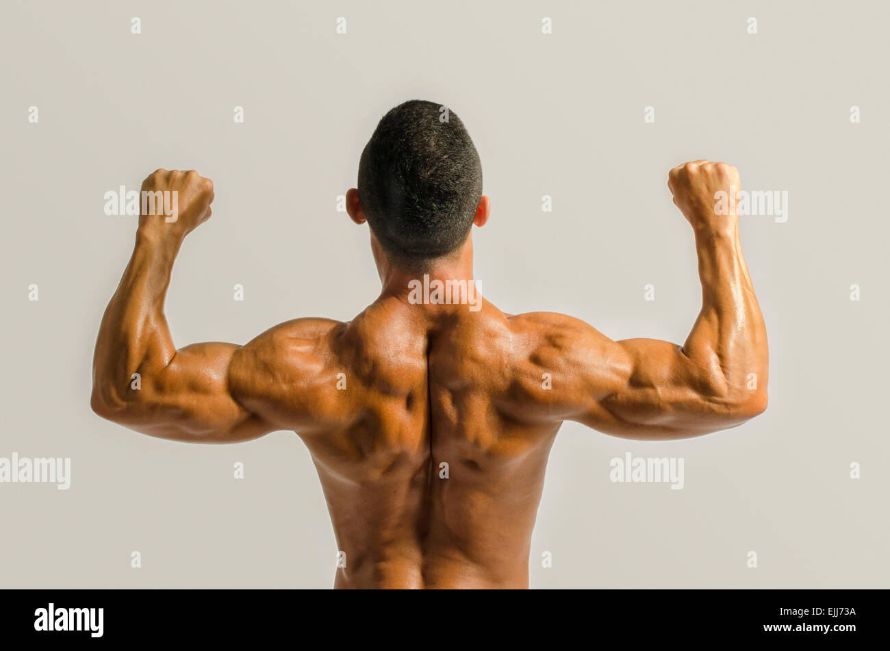 Bodybuilder showing his back and biceps muscles, personal fitness trainer. Strong man flexing his muscles Stock Photo