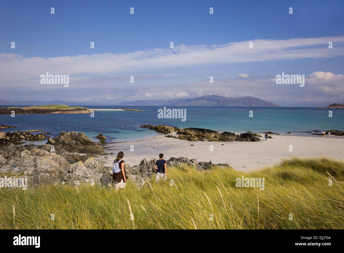 young couple strolling on beach at iona exploring sea shore on beautiful summer's day Stock Photo