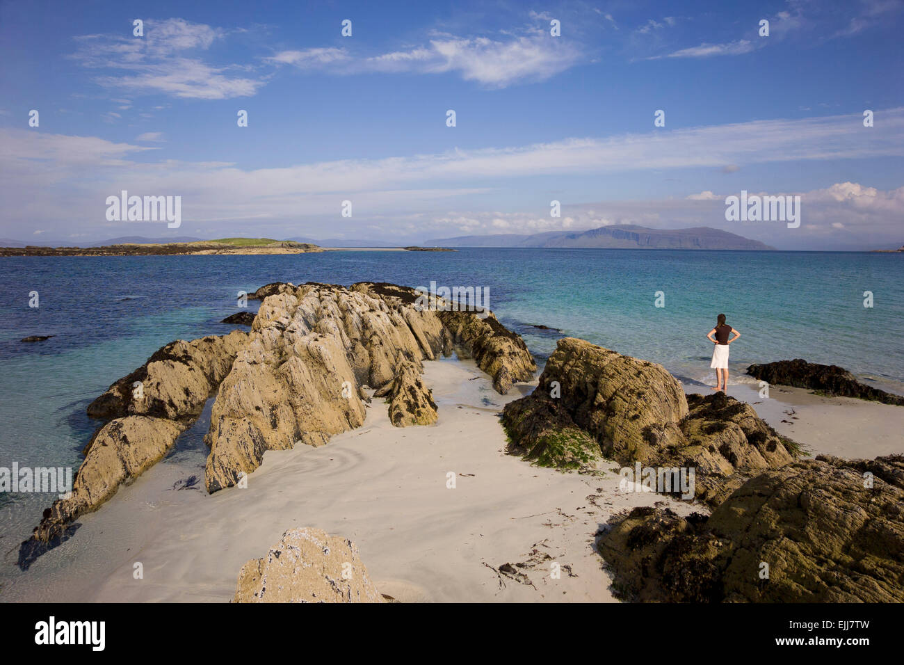 iona beach and young woman gazing out to the blue sea Stock Photo