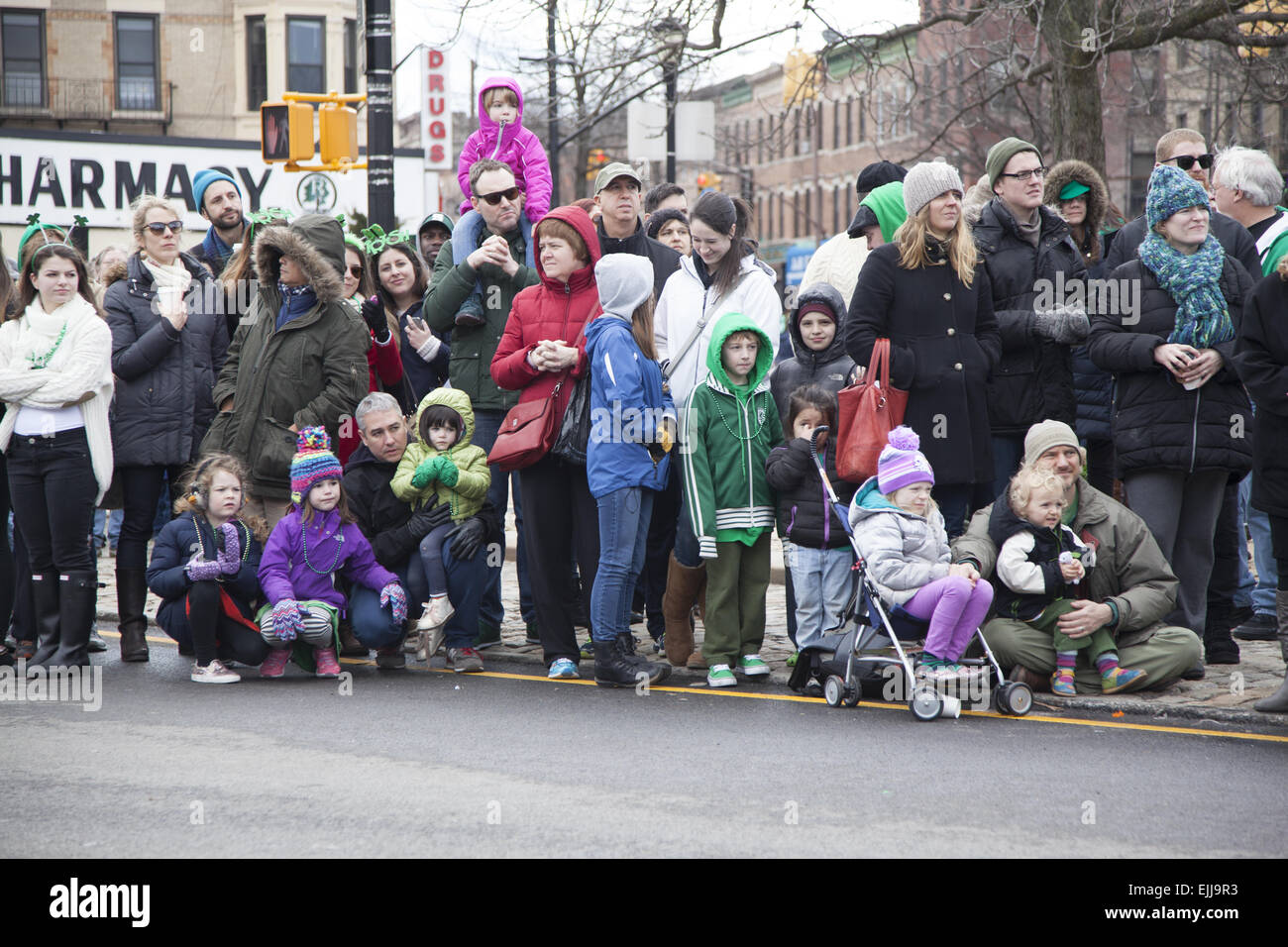 Spectators, mostly from the neighborhood, watch the St. Patrick's Day Parade in Park Slope, Brooklyn, NY. Stock Photo