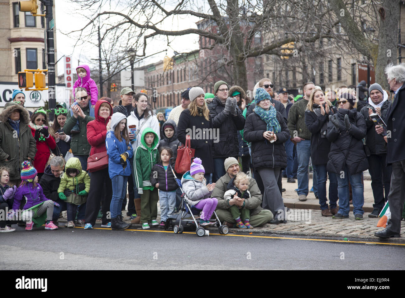 Spectators, mostly from the neighborhood, watch the St. Patrick's Day Parade in Park Slope, Brooklyn, NY. Stock Photo