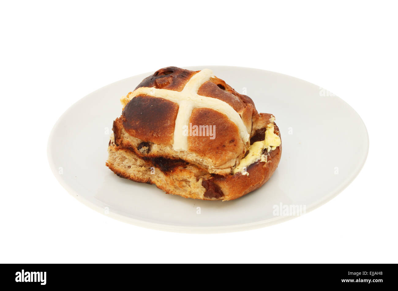 Single toasted and buttered hot cross bun on a plate isolated against white Stock Photo