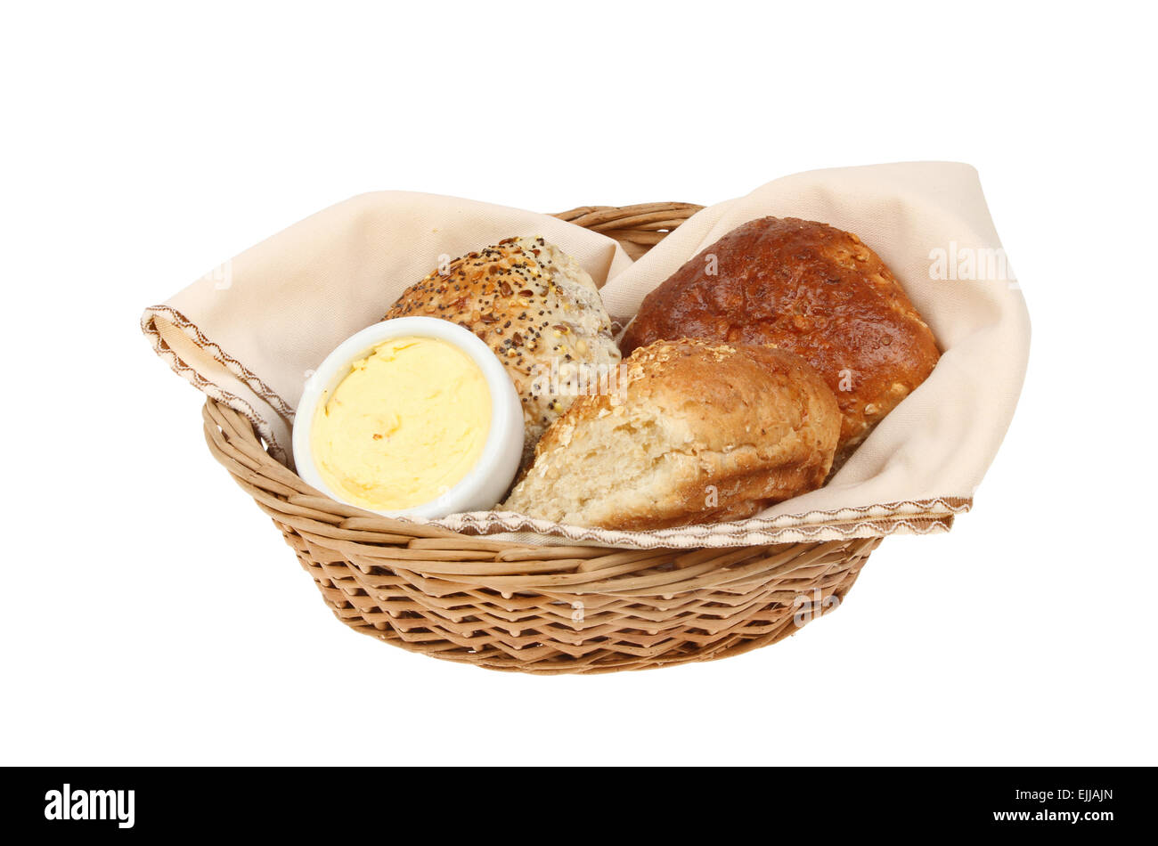 Bread rolls with butter in a wicker basket with a serviette isolated against white Stock Photo