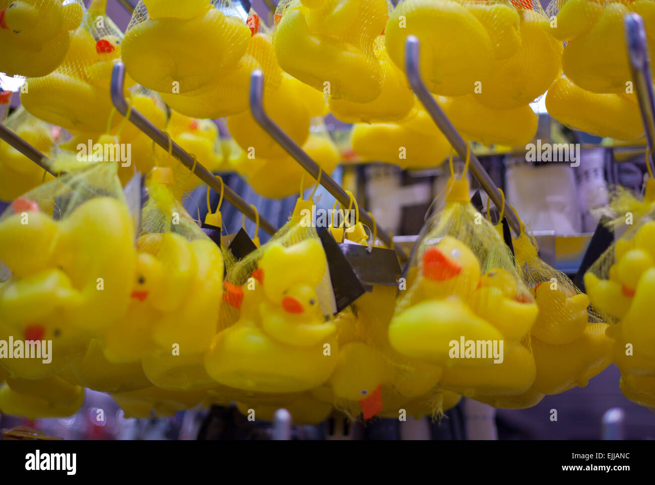 Rubber ducks hanging from supermarket shelves on baby products area. Selective focus Stock Photo