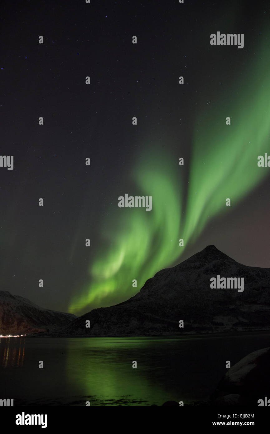 The Aurora Borealis in the night sky over a fjord close to Tromso ...
