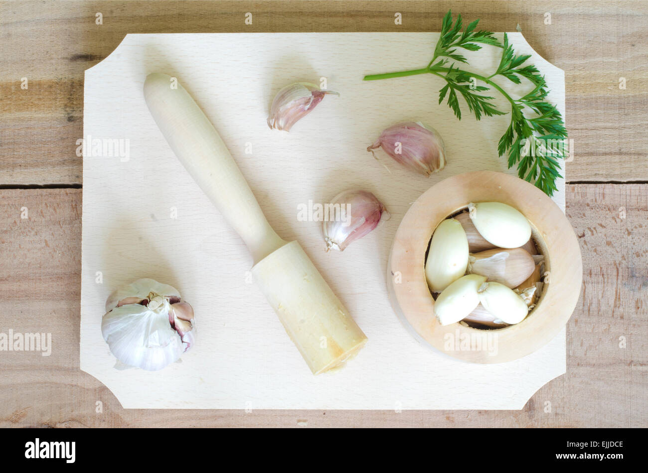 Garlic and parsley leaves isolated on wood background Stock Photo