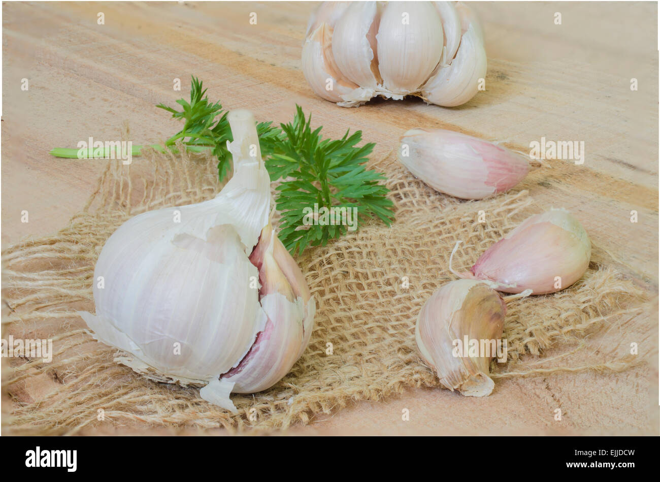 Garlic and parsley leaves isolated on wood background Stock Photo - Alamy