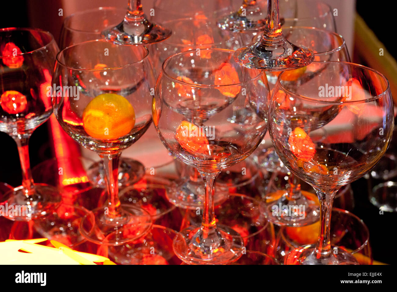Lots of wine glasses with orange inside, prepared for serve in a bar Stock Photo