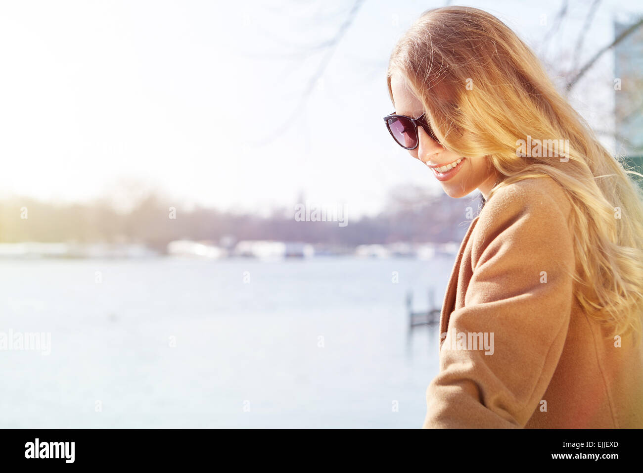 Smiling redhead outdoors backlit by sun Stock Photo