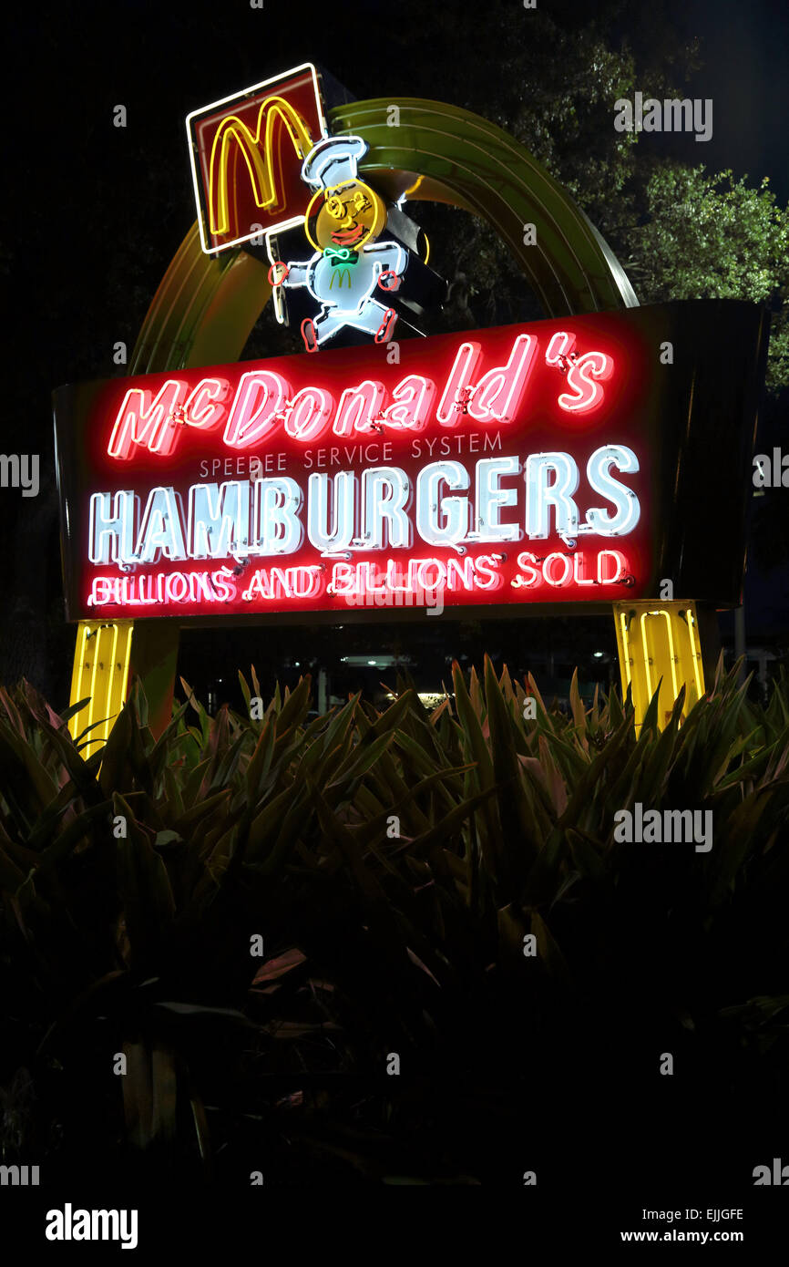 McDonalds fast food restaurant neon hamburger sign, golden arches light sign outside McDonald's exterior Stock Photo